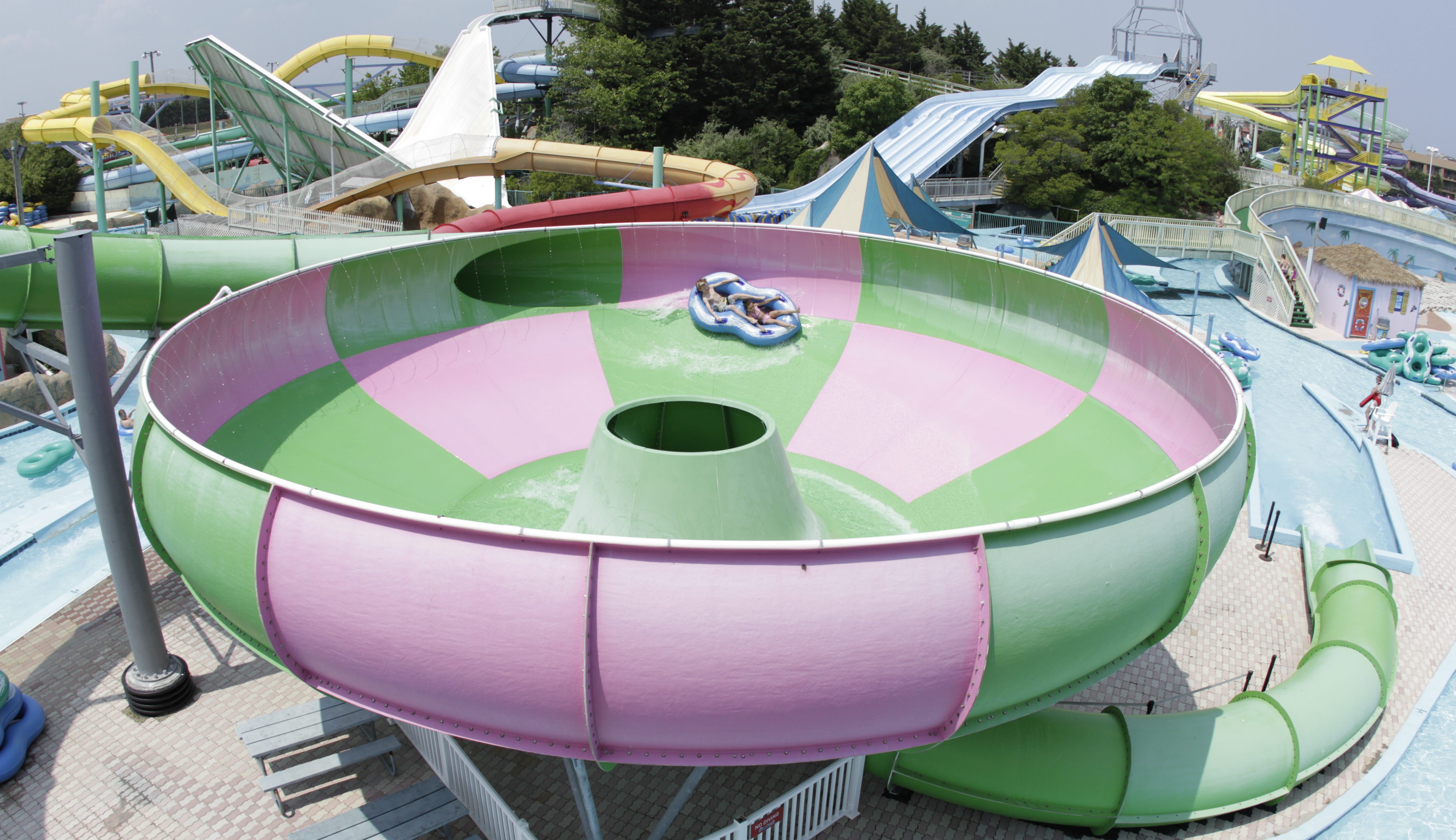 a pink and green hurricane shaped ride at a water park