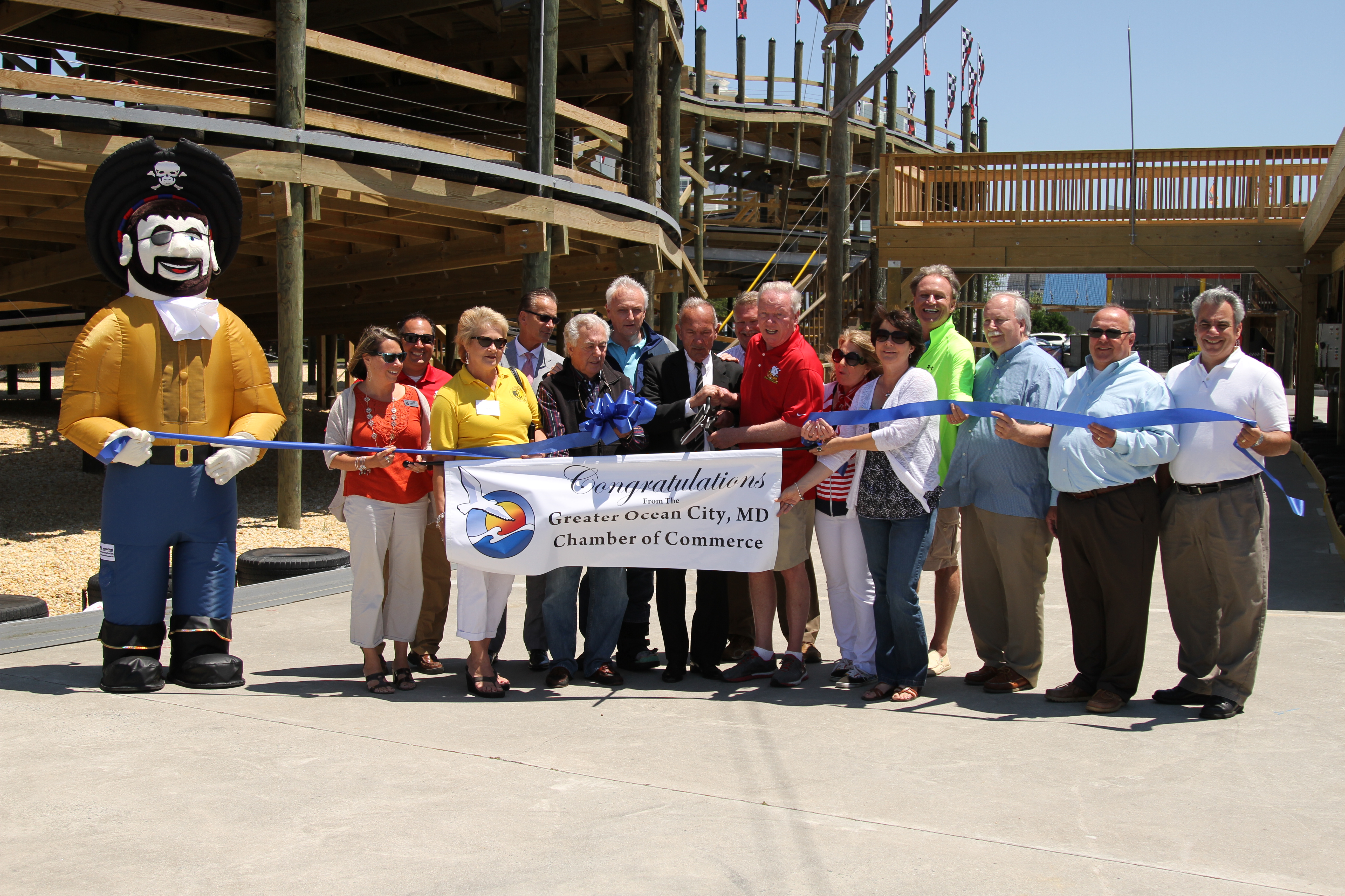 people standing behind a white banner with the words congratulations ocean city chamber of commerce