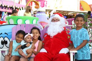 Santa in an amusment park with four children