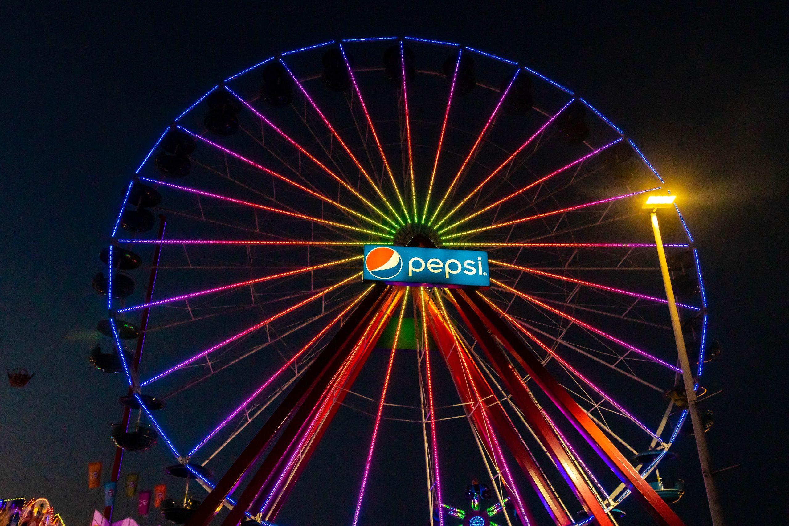Giant Ferris Wheel with rainbow LED lights and a Pepsi Sign in the Middle